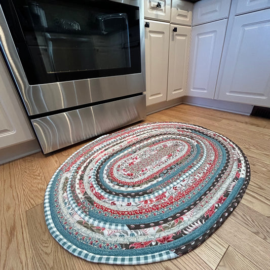 Cotton Kitchen Jelly Roll Rug with Burgundy, Teal and Taupe tones of floral quilt fabric.  Handmade in Canada and perfect as a Kitchen Rug, Bedside Rug or as a Luxury Bathmat.  Made by Home Stitchery Decor. 