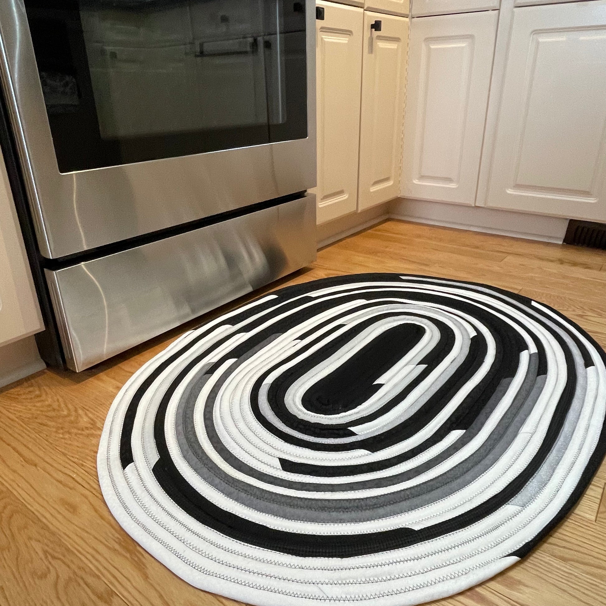Handmade Kitchen Jelly Roll Rug. Featuring black, grey and white tones of quilting cotton. Washable and durable this rug will last for years. Handmade in Canada by Home Stitchery Decor
