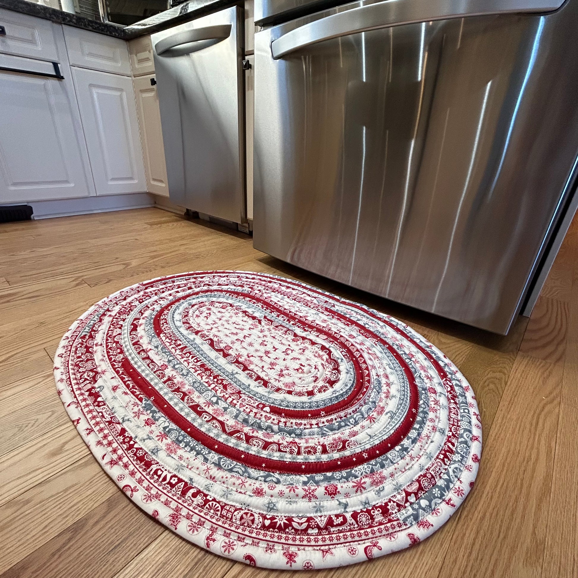 Handmade Christmas Kitchen Rug. Washable Cotton Jelly Roll Rug for Kitchen, Bedside or Bathmat. Featuring premium quilt cotton with red, white and grey Christmas prints. Made in Canada