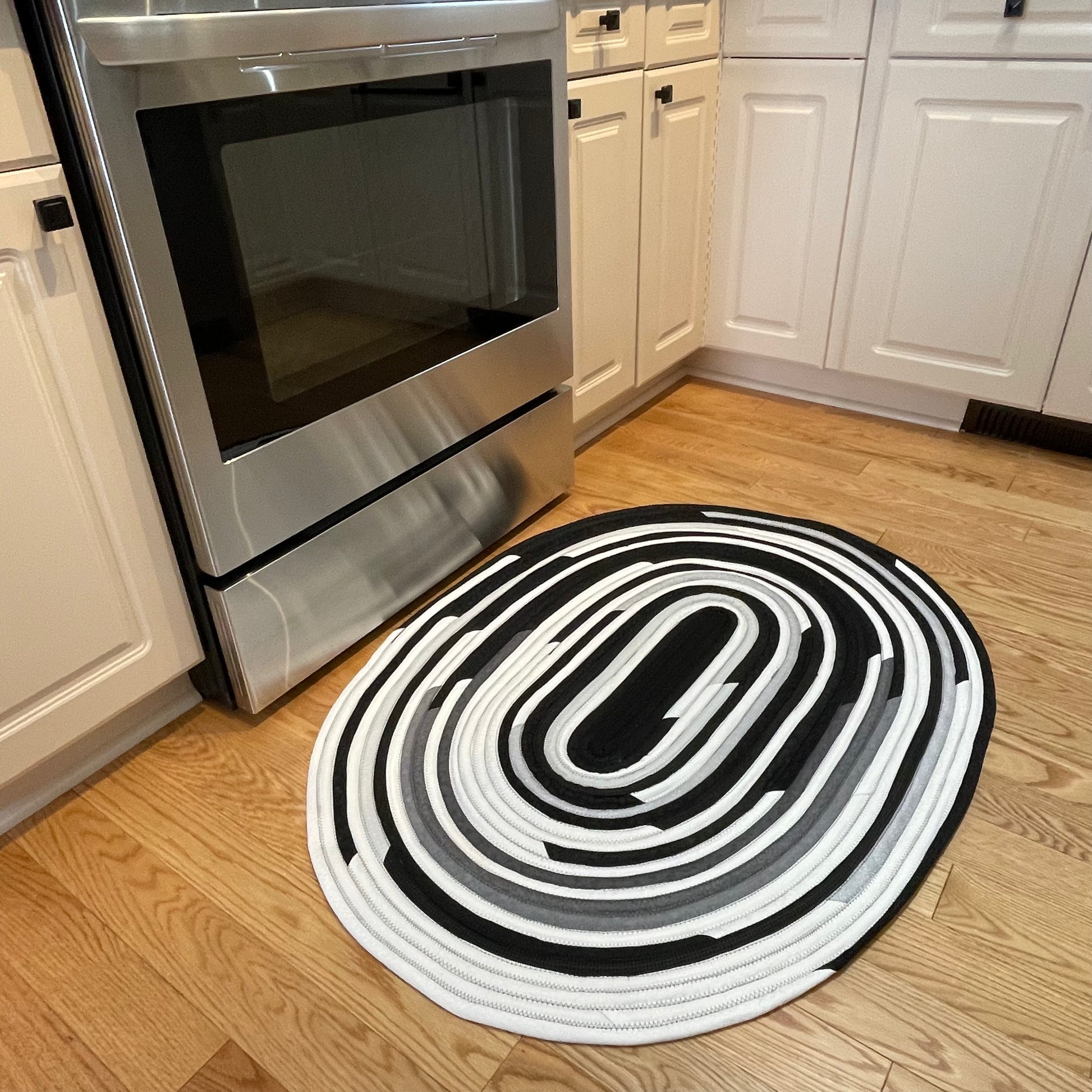 Handmade Kitchen Jelly Roll Rug. Featuring black, grey and white tones of quilting cotton. Washable and durable this rug will last for years. Handmade in Canada by Home Stitchery Decor