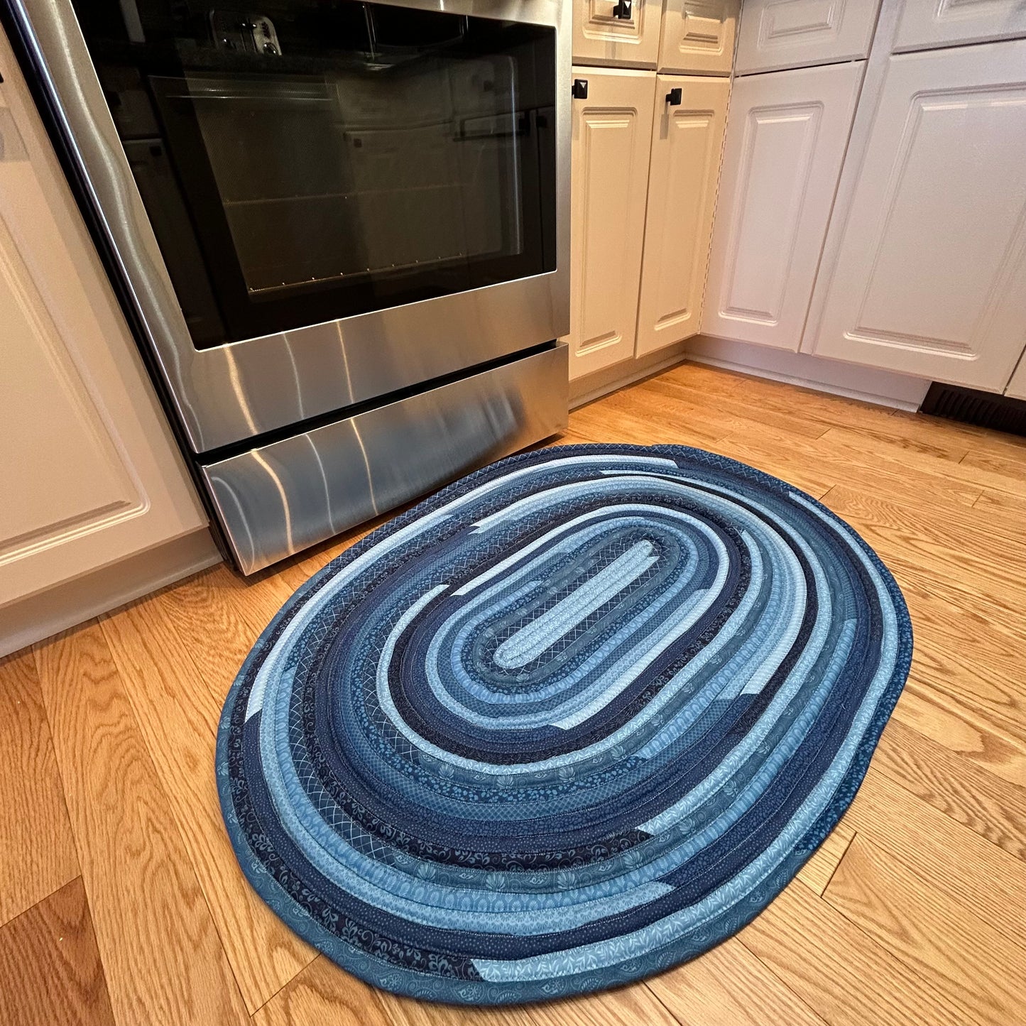 Blue Handmade Jelly Roll Rug for Kitchen. Or use as a bedside rug or luxury bathmat. It's cozy, washable, reversible and made to last. At Home Stitchery Decor we aim to bring beauty and function to home decor just like grandma used to make!