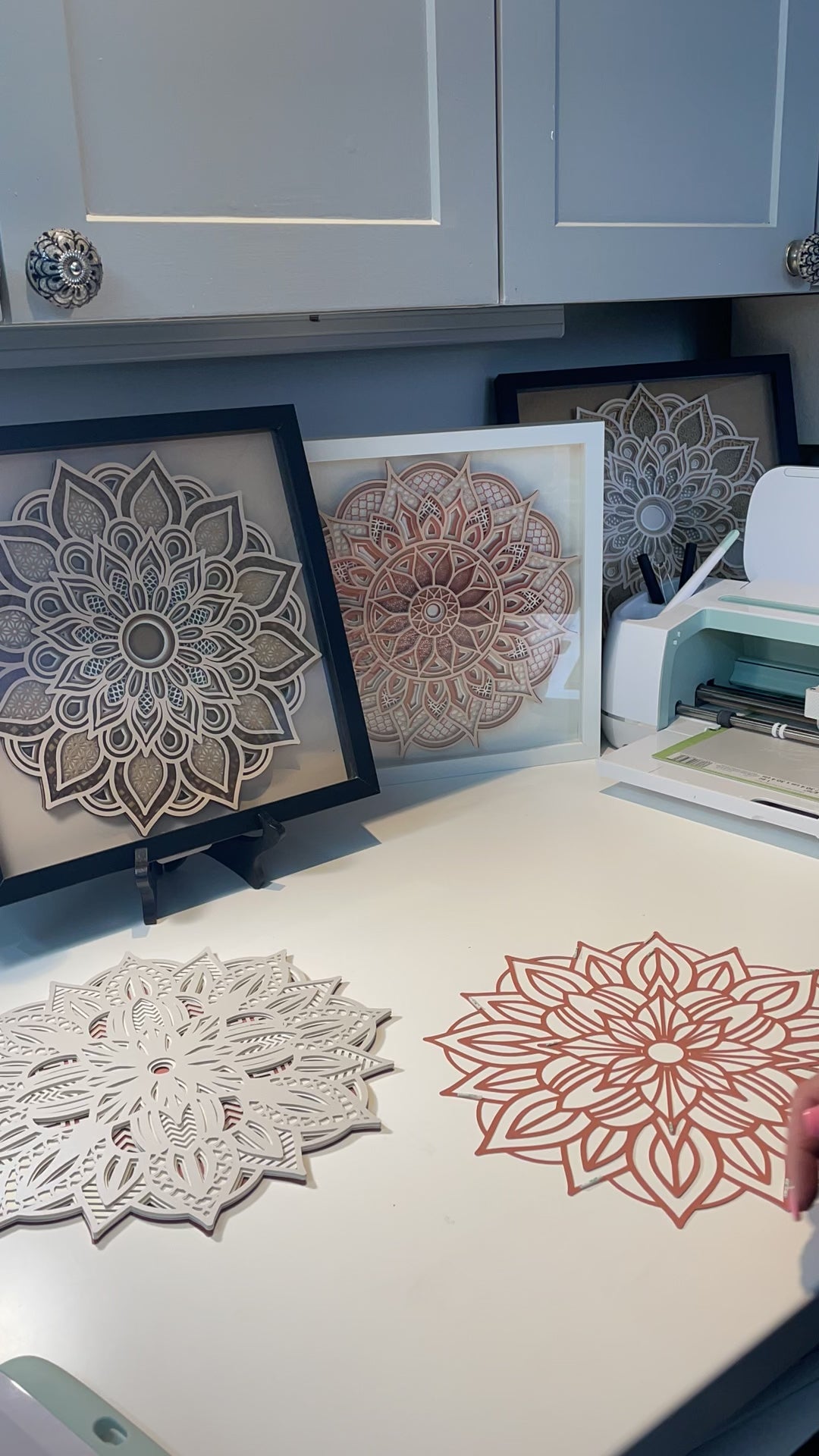 Watch as I assemble a 3d layered Mandala.  I'm using double sided 3m sticky tape and the fine point needle tool from Cricut. In the background are framed Mandalas in Shadow boxes.  Purchase your favorite 3d Layered Mandala Design at Home Stitchery Decor and follow along with the step-by-step tutorial.  3d Layered Mandala SVG instant download designs by Home Stitchery Decor