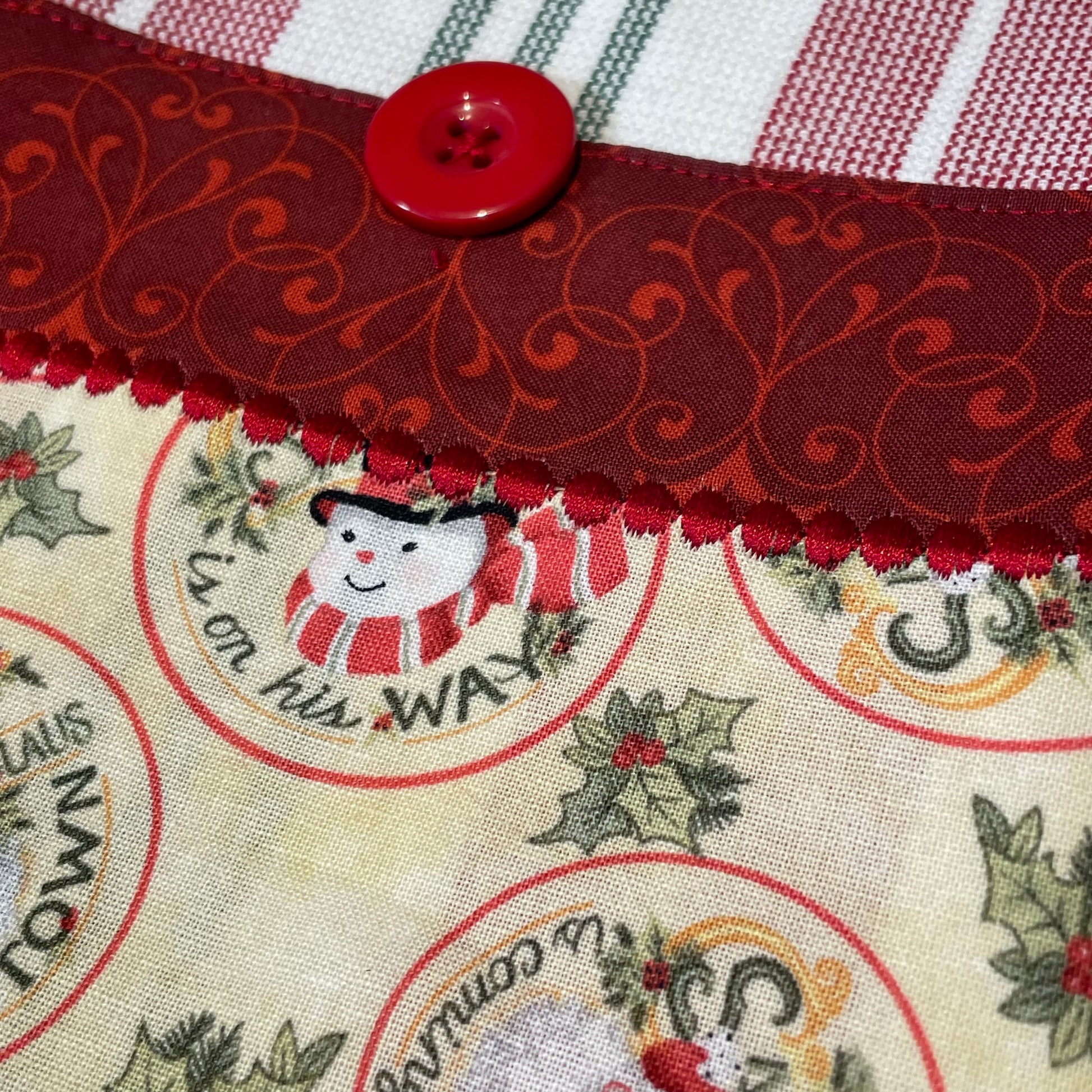 Retro Santas and Snowmen adorn this red Christmas Tea Towel. Handcrafted in Canada. Part of a mix and match collection of home decor. Shop the look at Home Stitchery Decor.