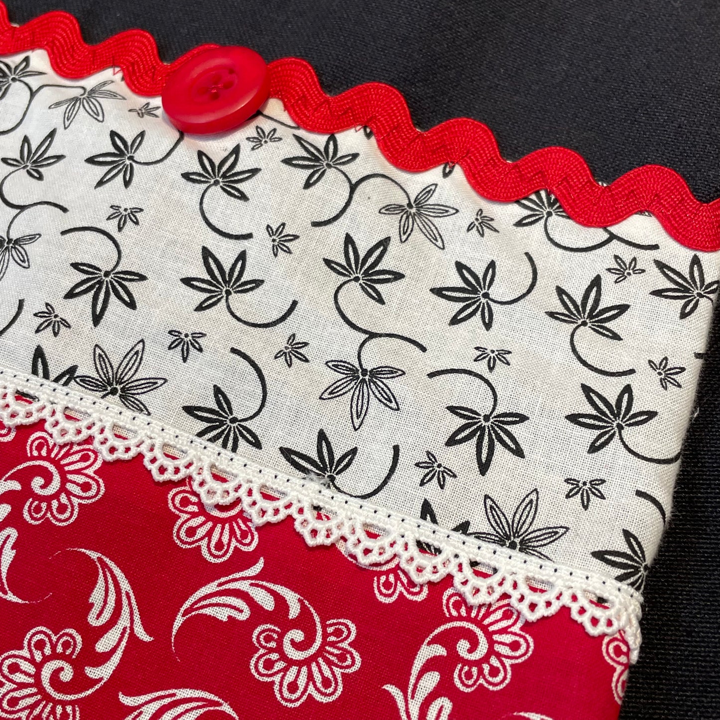Farmhouse dish towel. Black cotton toweling with quilting cotton accents. Featuring red Ric Rac, white delicatepolyester lace and button embellishments. Part of a mix and match farmhemian home accents decor line. Browse all the collections online. And be sure to tune into the Home Stitchery Decor YouTube Channel for fabulous fun farmhouse DIY Decor tutorials.