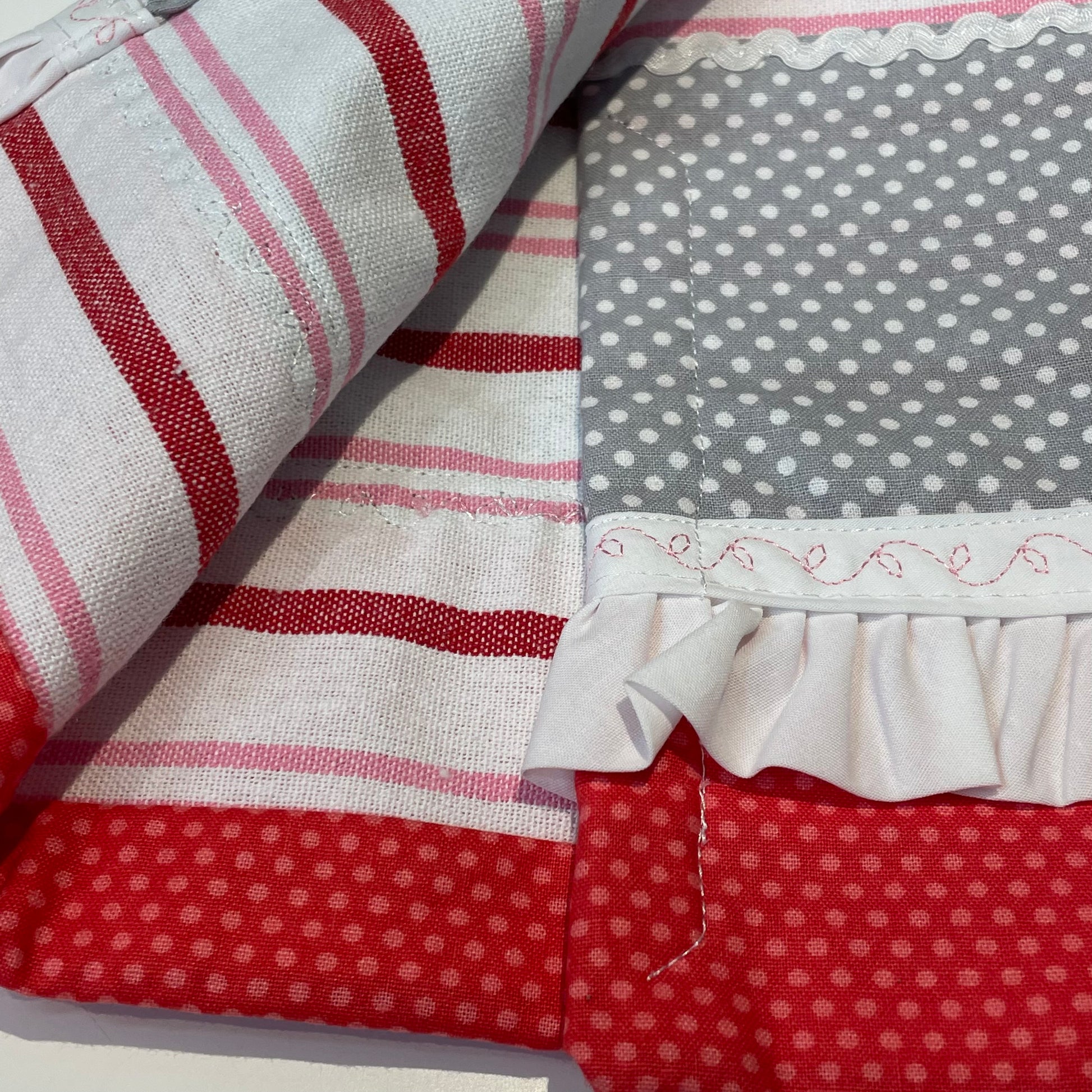 Fun Retro Pink Polka Dot Dish Towel. White, Pink, Red Toweling with polka dot quilting fabric, ric rac, frilled broadcloth and button embellishments. Topped off with some floral embroidery stitching. Part of a coordinated collection of farmhouse fabulous decor. Shop the entire collection. And be sure to follow along on the Home Stitchery Decor YouTube Channel where the farmhouse diy decor fun never stops!