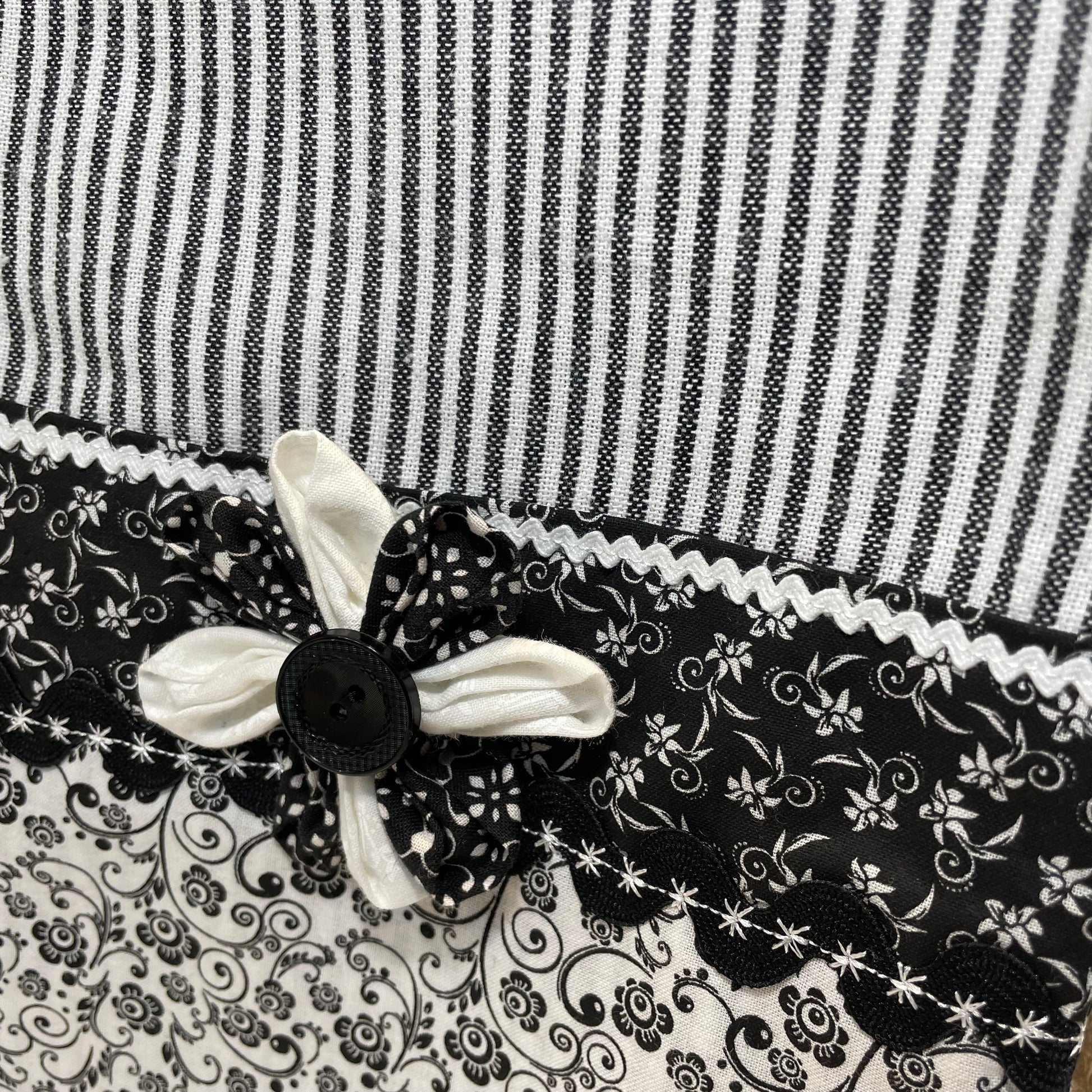 Black and white retro farmhouse tea towel. Featuring black and white striped toweling. Black and white floral quilting cotton accents with white and black ric rac, a handcrafted flower with button center and embroidery stitching. Part of a coordinating collection of farmhouse decor. Browse the entire collection. Then head over to the Home Stitchery Decor YouTube Channel for more Farmhouse DIY Decor Fun. See you there!