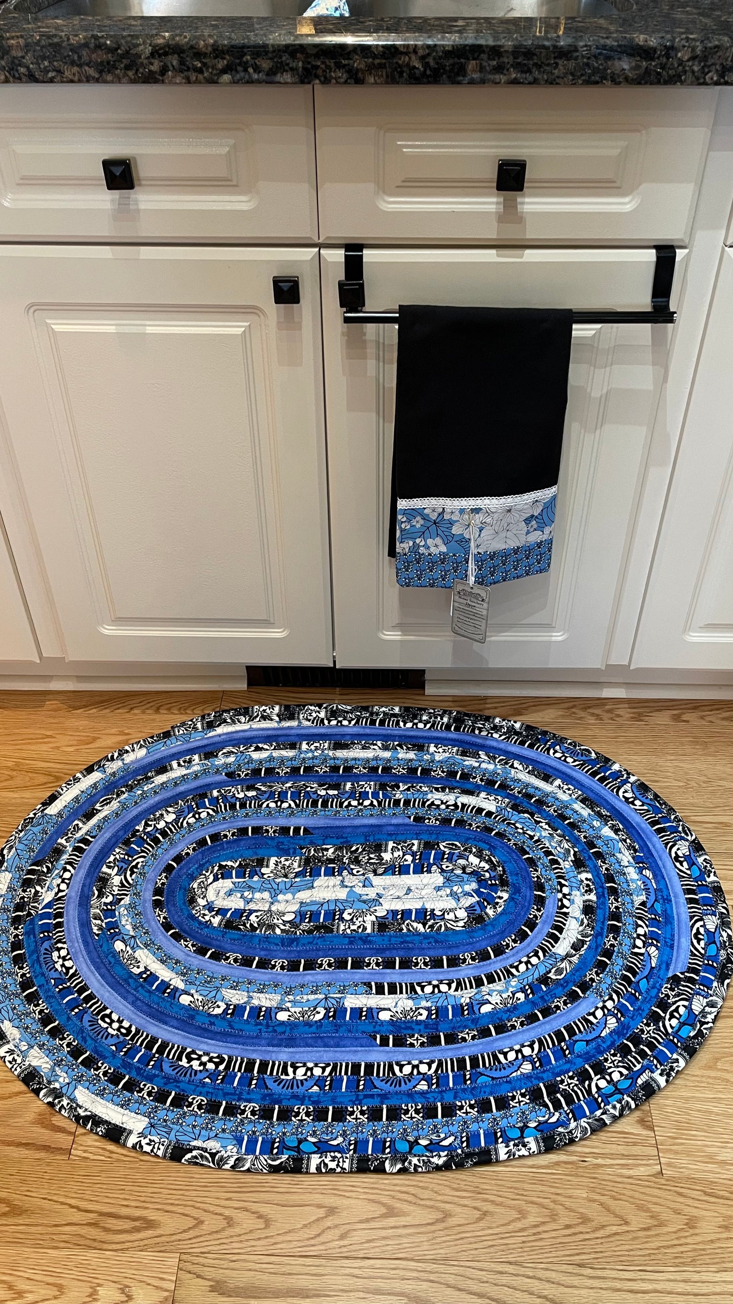 Vibrant blue, black and white kitchen accent rug. Washable handcrafted kitchen accent rug. Can also be used as a bedside rug, luxury bathmat or nursery room rug. Made in Canada and part of a collection of mix and match decor. Shop all the products or follow along on the Home Stitchery Decor YouTube Channel for sewing tutorials including JellyRoll Rug Tutorials.