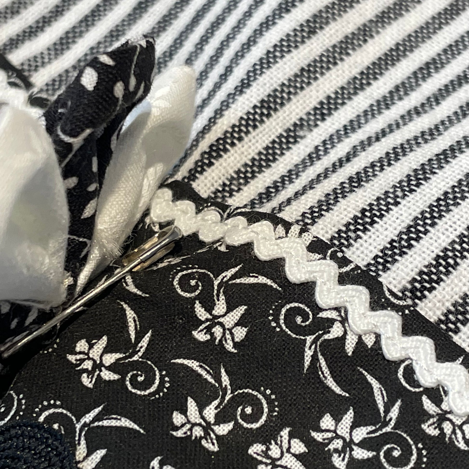 Black and white retro farmhouse tea towel. Featuring black and white striped toweling. Black and white floral quilting cotton accents with white and black ric rac, a handcrafted flower with button center and embroidery stitching. Part of a coordinating collection of farmhouse decor. Browse the entire collection. Then head over to the Home Stitchery Decor YouTube Channel for more Farmhouse DIY Decor Fun. See you there!