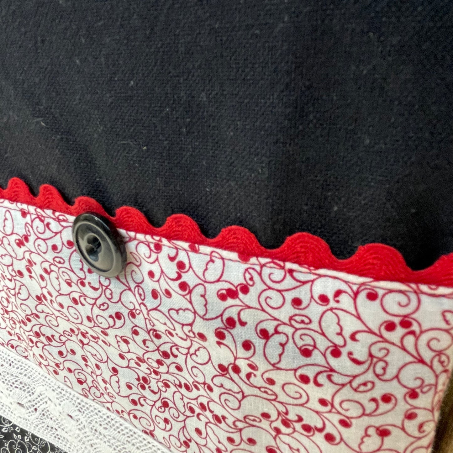 Farmhouse dish towel. Black cotton toweling with quilting cotton accents. Featuring red Ric Rac, wide white polyester lace and button embellishments. Part of a mix and match farmhemian home accents decor line. Browse all the collections online. And be sure to tune into the Home Stitchery Decor YouTube Channel for fabulous fun farmhouse DIY Decor tutorials.