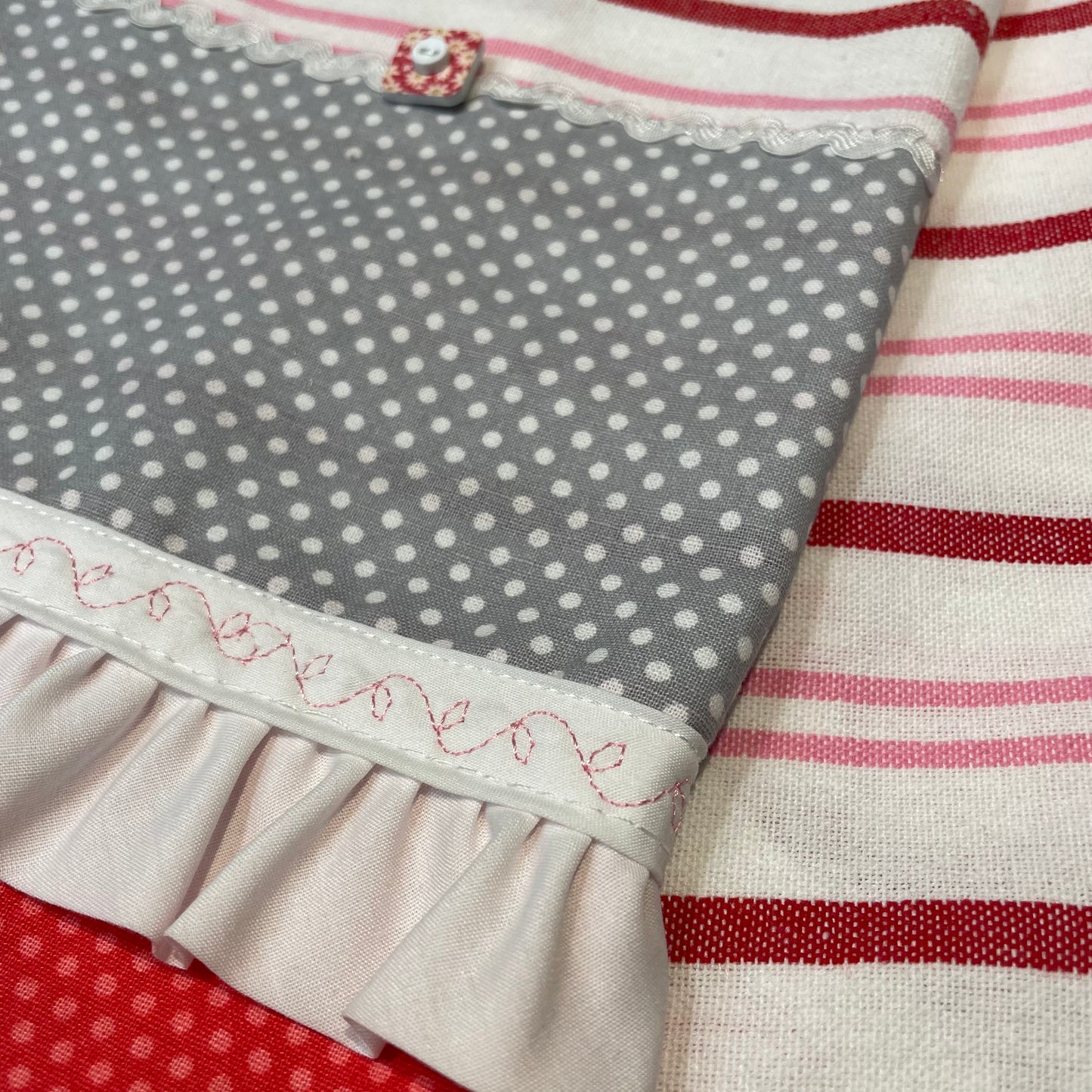 Fun Retro Pink Polka Dot Dish Towel. White, Pink, Red Toweling with polka dot quilting fabric, ric rac, frilled broadcloth and button embellishments. Topped off with some floral embroidery stitching. Part of a coordinated collection of farmhouse fabulous decor. Shop the entire collection. And be sure to follow along on the Home Stitchery Decor YouTube Channel where the farmhouse diy decor fun never stops!