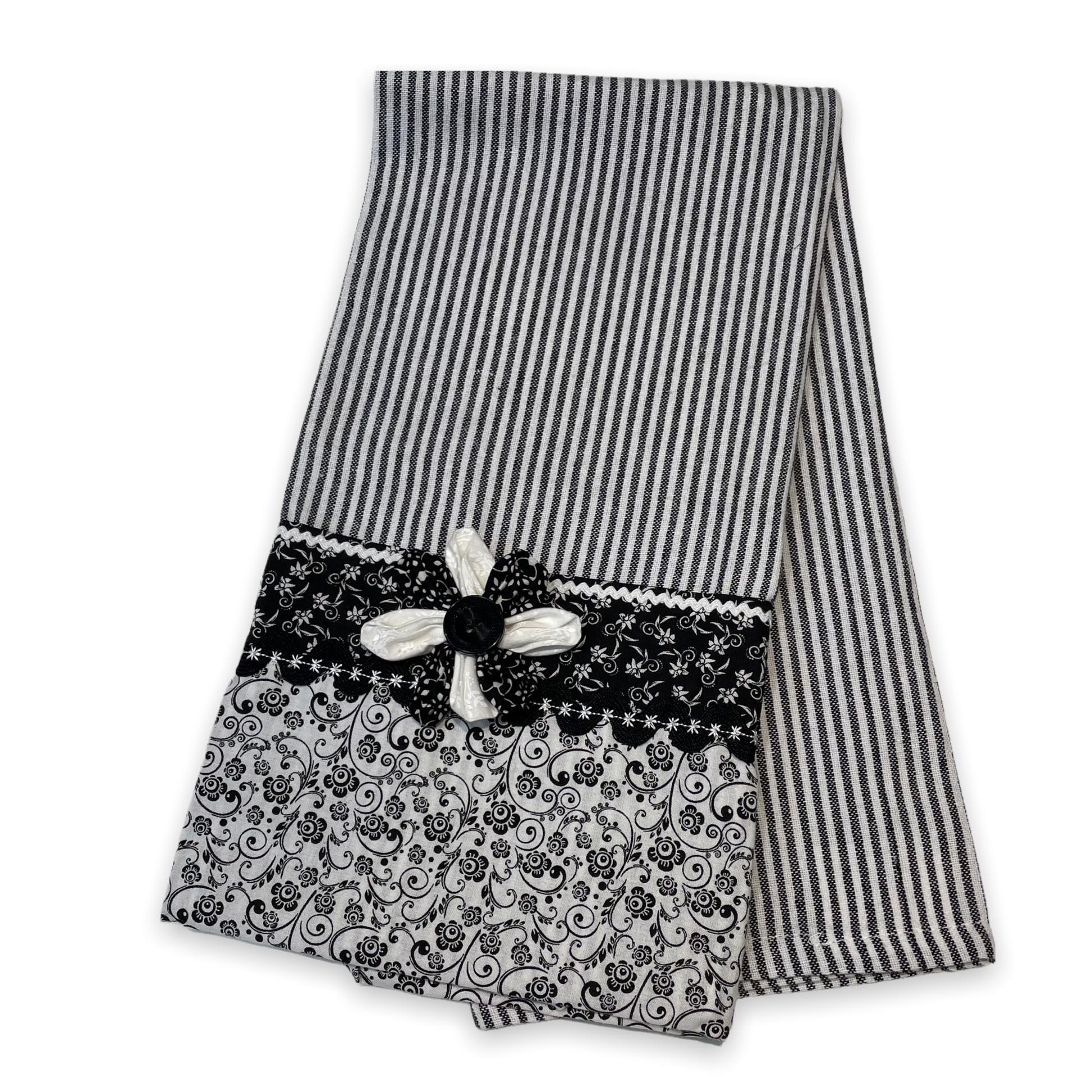 Black and white retro farmhouse tea towel. Featuring black and white striped toweling. Black and white floral quilting cotton accents with white and black ric rac, a handcrafted flower with button center and embroidery stitching. Part of a coordinating collection of farmhouse decor. Browse the entire collection. Then head over to the Home Stitchery Decor YouTube Channel for more Farmhouse DIY Decor Fun. See you there!
