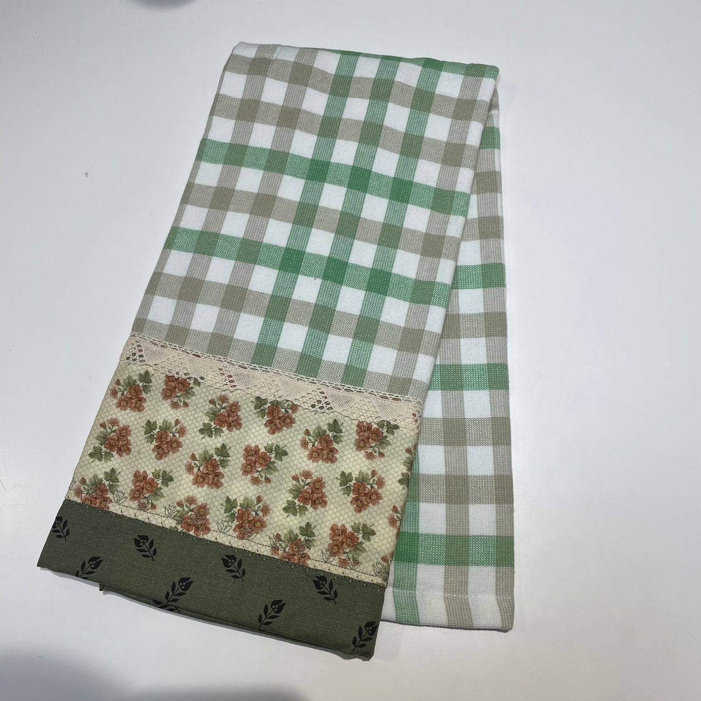 Farmhouse Dish Towel with green and white check towelins and orange and green cotton fabric decorations. Featuring embroidery stitching and beige cotton lace trim. Handcrafted in Canada by Home Stitchery Decor. Purchased coordinating Farmhouse Decor or follow along with tutorials on the Home Stitchery Decor YouTube Channel. 