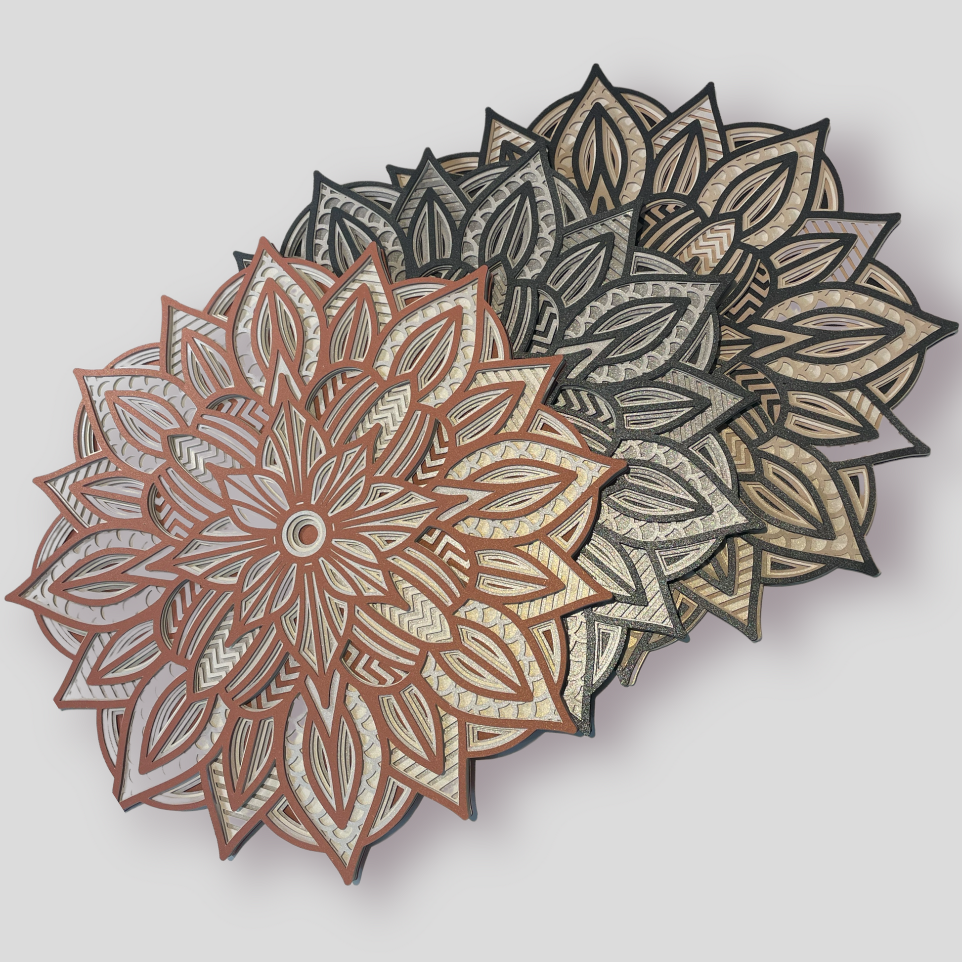 3 examples of our 3d Layered Mandala SVG Files in different colors. These 3d Layered Mandalas are perfectly sized for a 12 inch Shadow Box.  Grab your Cricut Maker and our instant download 3d Layered Mandala SVG Files.  Follow along with the complete Mandala tutorial included with your purchase. Find your favorite 3d Layered Mandala design at www.homestitcherydecor.com