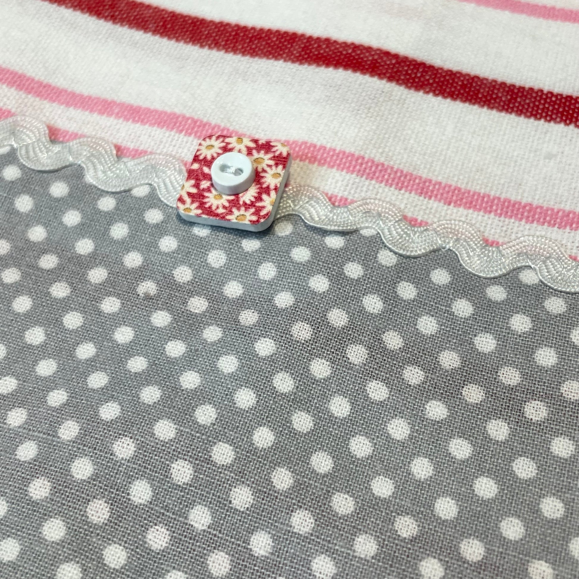 Fun Retro Pink Polka Dot Dish Towel. White, Pink, Red Toweling with polka dot quilting fabric, ric rac, frilled broadcloth and button embellishments. Topped off with some floral embroidery stitching. Part of a coordinated collection of farmhouse fabulous decor. Shop the entire collection. And be sure to follow along on the Home Stitchery Decor YouTube Channel where the farmhouse diy decor fun never stops!