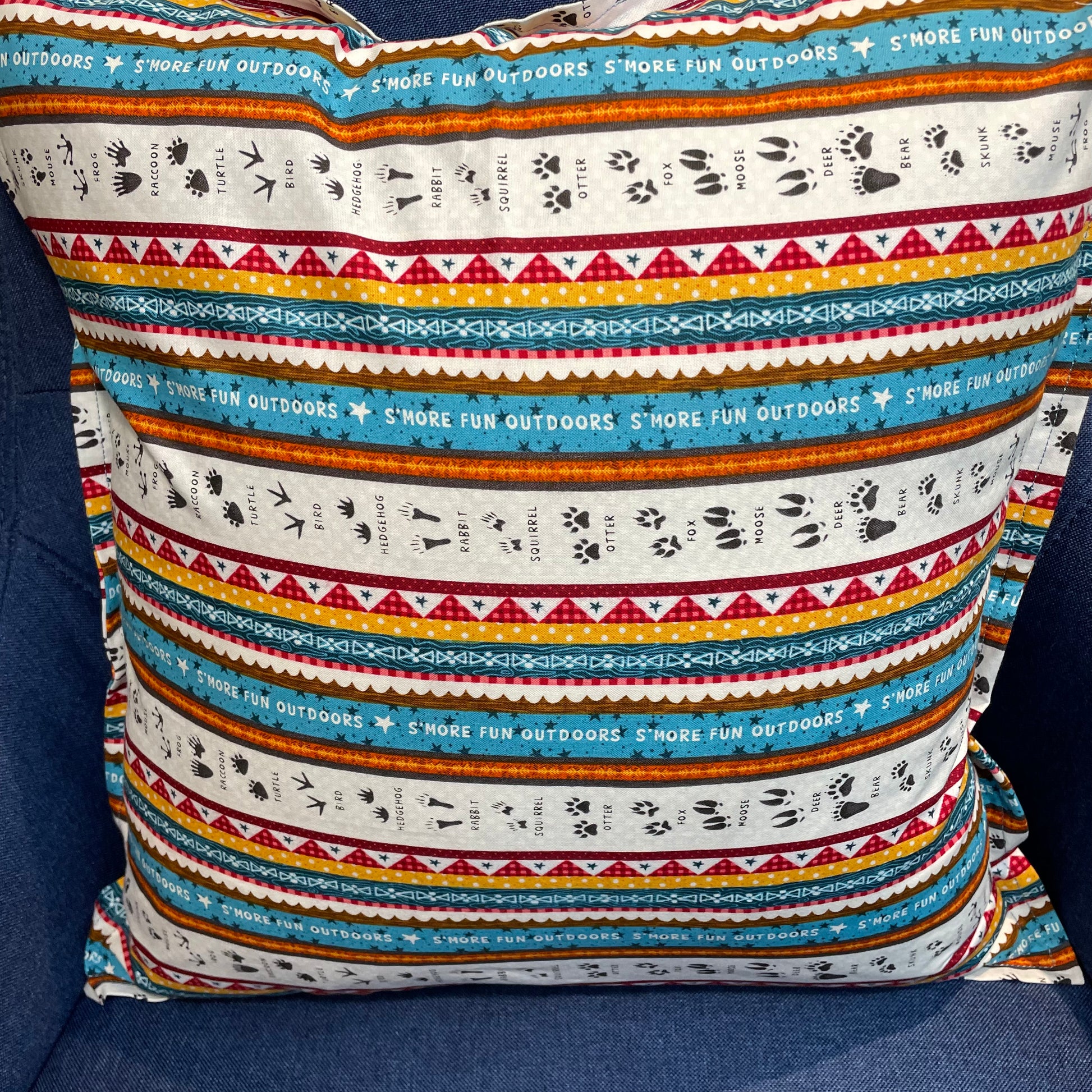 Camping Decorative Pillow for your RV, Camper Decor. Let's go camping with mix and match decor. Shop the collection and follow along on the Home Stitchery Decor YouTube Channel. Pillow in white, teal, red, yellow and black. Woodland tracks camping themed pillow.